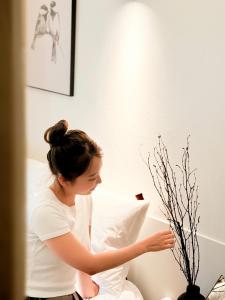 a woman sitting on a bed holding a piece of paper at Stay 42 Dongmyo in Seoul