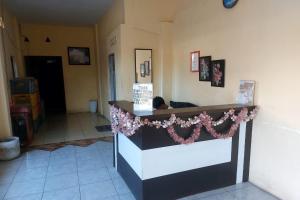 PalopoにあるHotel Warnaの花が飾られたレストランのカウンター