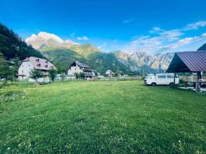 a van parked in a field with mountains in the background at Lokthi Guesthaose in Theth