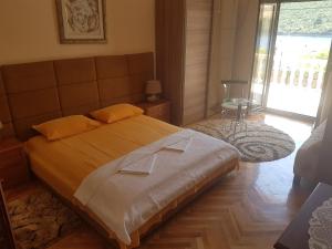 a bedroom with a large bed and a large window at Apartments Grispolis in Tivat