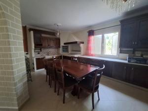 ドゥラスにあるVilla Escapeの木製のテーブルと椅子のあるキッチン