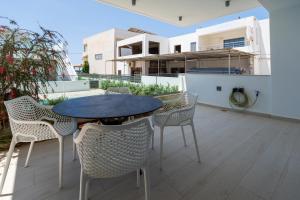 a patio with a table and chairs on a balcony at Marina Bay Aparment in Pilalímata
