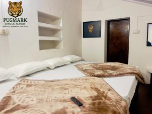 two beds in a room with a tiger sign on the wall at Pug Mark Jungle Resort - Masinagudi in Masinagudi
