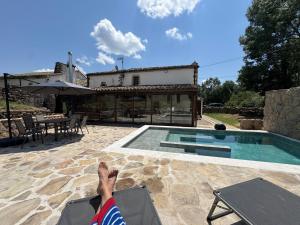 una persona sentada en una silla junto a una piscina en Villa El Molino Blanco, en Molinos de Razón