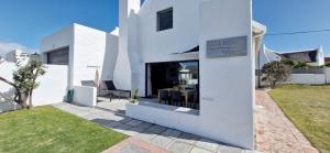 ストロイスバーイにあるAmia House Struisbaaiの庭のテーブル付白い家