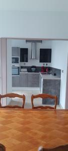 cocina con 2 sillas y mesa de madera en Chez MaLouNa - 15 min de la Baie de Somme, en Friville-Escarbotin 5 fotos más