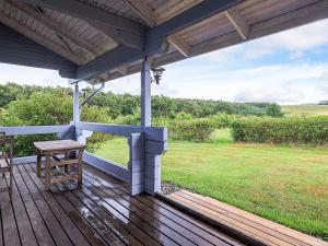 a porch with a table and a bench on it at 6 person holiday home in Roslev-By Traum in Flovtrup