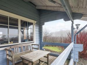 a wooden bench sitting on the porch of a house at 6 person holiday home in Roslev-By Traum in Flovtrup