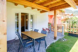a wooden table and chairs on a patio at Residence Al Caminetto in Molveno