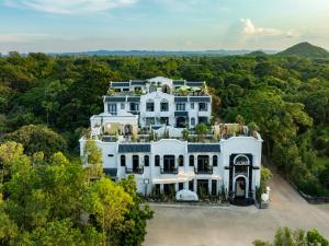 an aerial view of a white mansion in the forest at La Charm Ninh Binh Hotel & Spa in Ninh Binh