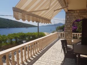 a balcony with an umbrella and a view of the water at Apartments Grispolis in Tivat