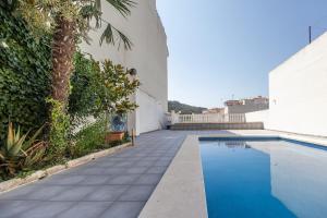 a swimming pool next to a building with a palm tree at Casa Potelos by Concept Flats in Navajas