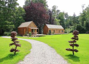 a gravel path leading to a barn and a house at Les Cabanes du Moulin de l'Ortille & SPA in Compiègne