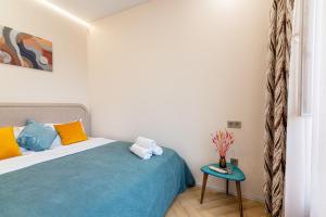 a bedroom with a bed and a side table at Комфортабельная квартира в ЖК Meridian Apartments in Almaty