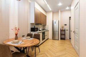 a kitchen and dining room with a table and a refrigerator at Комфортабельная квартира в ЖК Meridian Apartments in Almaty +22 photos