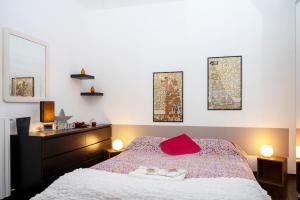 a bedroom with a bed with red pillows on it at Casa di Flo - Medieval City Centre with WiFi & AC in Ferrara +9 photos