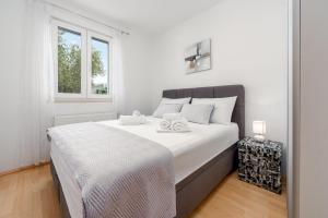 a bedroom with a large white bed with a window at Villa Štrkalj ZadarVillas in Murvica +55 photos