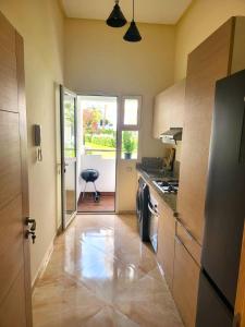 a kitchen with a sink and a stove at Superbe appartement à bouznika avec vue sur piscine et jardin privatif in Bouznika