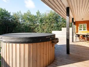 a wooden deck with a hot tub on a patio at 7 person holiday home in Grenaa in Grenå