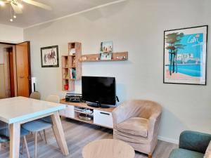 a living room with a television and a table and chairs at Appartamento a due passi da Maria Pia in Alghero