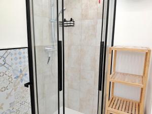 a shower with a glass door and a shelf at Appartamento a due passi da Maria Pia in Alghero