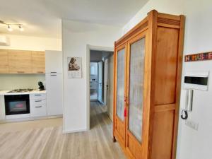 a kitchen with a wooden door in a room at Appartamento a due passi da Maria Pia in Alghero +9 photos