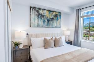 a bedroom with a white bed and a window at Sugarhouse! Mountain View 3BR, 2BA Gym, Parking in Salt Lake City