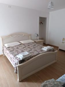 a bedroom with a large bed with a white bed frame at OASI FELIZ Minturno in Minturno