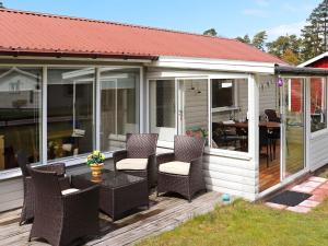 a screened in deck with chairs and a table at 5 person holiday home in MELLBYSTRAND in Mellbystrand