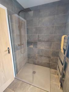 a shower with a glass door in a bathroom at Chic 2-Bed Loft Bungalow, Cleveleys, Near Beach in Blackpool +16 photos