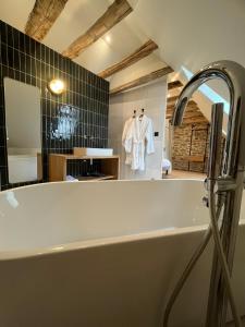 a bath tub in a bathroom with a mirror at Maison de Lacam in Castanet
