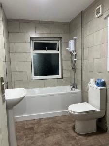 a bathroom with a white tub and a toilet and a window at Lifford Lane in Birmingham
