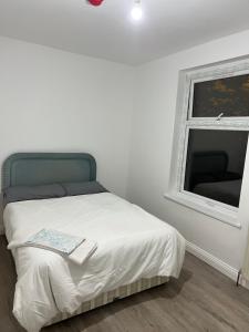 a white bedroom with a bed and a window at Lifford Lane in Birmingham