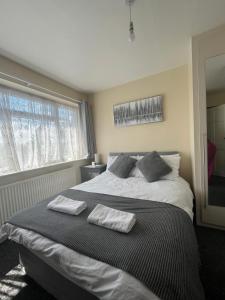 a bedroom with a large bed with two towels on it at Concord House, 3 bedroom house, 2 baths in Rainham, in Dagenham Dock