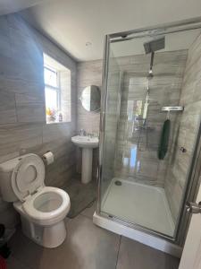 a bathroom with a shower and a toilet and a sink at Concord House, 3 bedroom house, 2 baths in Rainham, in Dagenham Dock