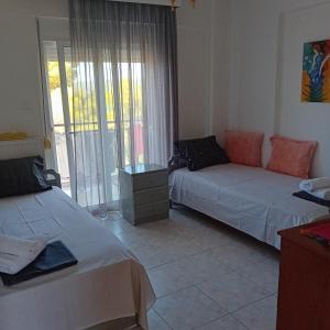 a living room with two beds and a window at Blue and Green in Neos Marmaras +8 photos