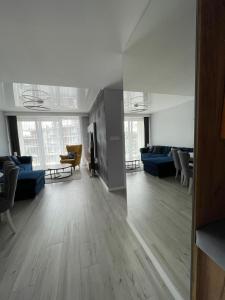 a living room with blue couches and tables and windows at Apartament Holiday Crystal in Rewal