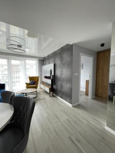a living room with a couch and a table at Apartament Holiday Crystal in Rewal