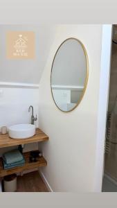 a bathroom with a sink and a mirror on a wall at Petite maison à 1km de la plage in Batz-sur-Mer