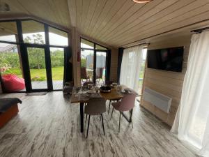 a dining room with a table and chairs and windows at Wally House in Glebovka