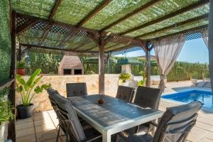 a patio with a wooden pergola and a table and chairs at Villa Oasis in Lora del Río
