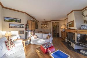a living room with white couches and a kitchen at Chesa Pradatsch Suot 5 - Celerina in Celerina