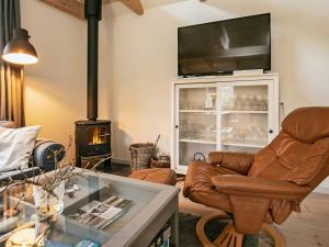 a living room with a couch a chair and a fireplace at 5 person holiday home in Millinge in Millinge