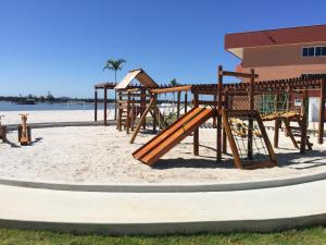Un parque infantil en la playa cerca de un edificio. en Melhor do paraíso em arraial do cabo, en Arraial do Cabo