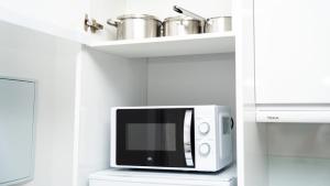 un horno microondas sentado en un estante en una cocina en Studio New Complete 4 pax, en Madrid 5 fotos más