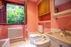 Un baño con inodoro, lavabo y ventana. en Villa Scagliola, en Verbania