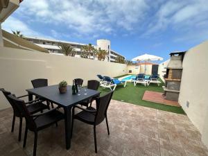 a patio with a table and chairs and a pool at DUPLEX C6 con PISCINA PRIVADA in Callao Salvaje