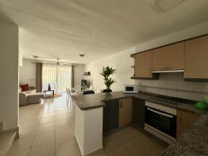 a kitchen with a counter and a living room at DUPLEX C6 con PISCINA PRIVADA in Callao Salvaje