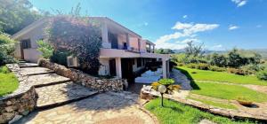a house with a stone wall and a yard at Villa Starlight vista mare La Caletta in Santa Lucia +34 photos