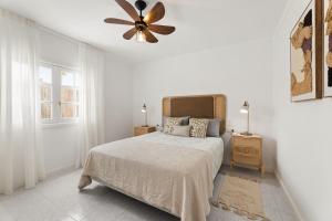 Un dormitorio blanco con una cama y un ventilador de techo. en Paraiso Marino by EscapeHome, en Los Pocillos 24 fotos más